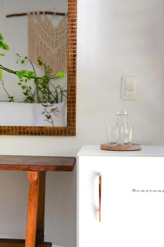 a mirror on a wall next to a white table at Pousada Habitat Caraíva in Caraíva