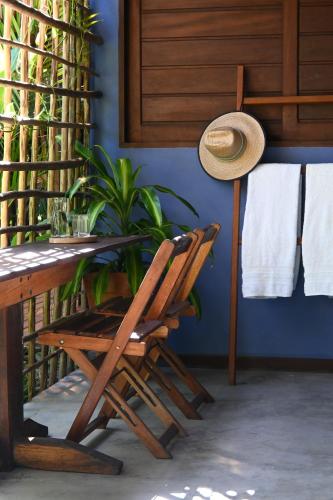 a room with a table and chairs and a plant at Pousada Habitat Caraíva in Caraíva