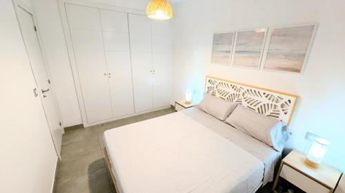een kleine slaapkamer met een wit bed en witte kasten bij Rincón del Atlántico in Rota
