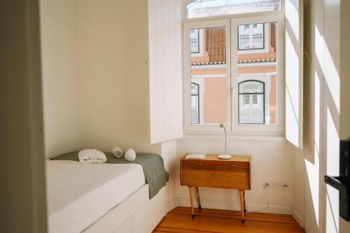 a small bedroom with a bed and a window at samesame living in Lisbon
