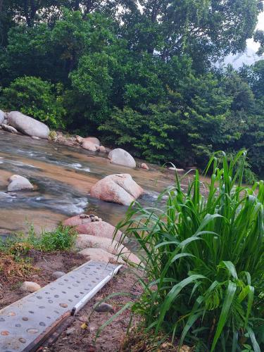 a river with rocks and a metal beam in the water at Casa Terraza in El Zaino