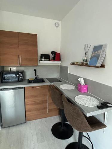 une cuisine avec un comptoir avec des chaises et un évier dans l'établissement First, à Bourges