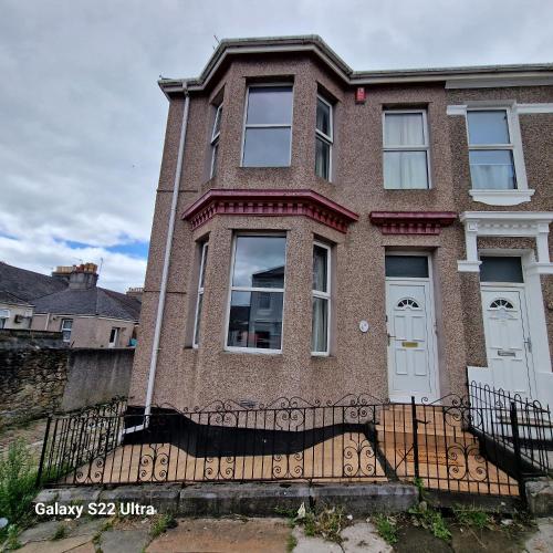 a brick house with a gate in front of it at 5 Bed Plymouth Home-Free Parking - Close to City Centre in Plymouth