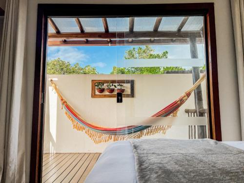 a bedroom with a hammock on a deck at Conchas do Mar Residence in Itacaré