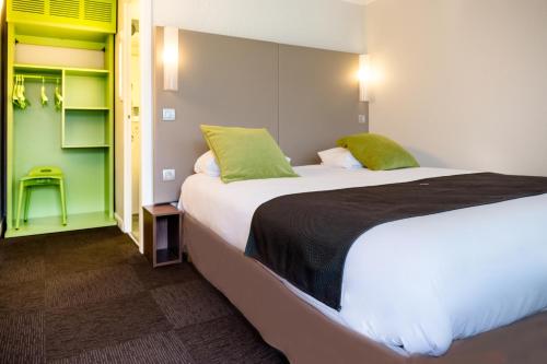 a hotel room with two beds with green accents at Hotel inn Design Laval in Laval