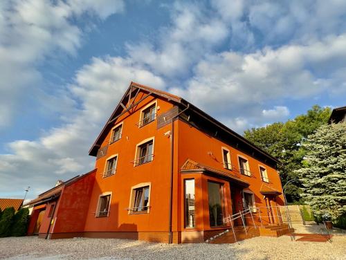 an orange building is under construction on a cloudy day at Villa Stylius in Gdańsk