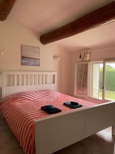 - une chambre dotée d'un lit avec deux chaussures noires dans l'établissement Agréable villa provençale avec piscine à deux pas des Alpilles, à Mollégès