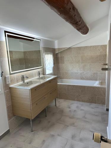 une salle de bain avec un lavabo et une baignoire dans l'établissement Agréable villa provençale avec piscine à deux pas des Alpilles, à Mollégès