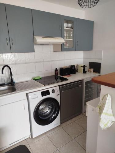 une cuisine avec un lave-linge et un lave-vaisselle dans l'établissement L'appartement de Juju, à Bayonne