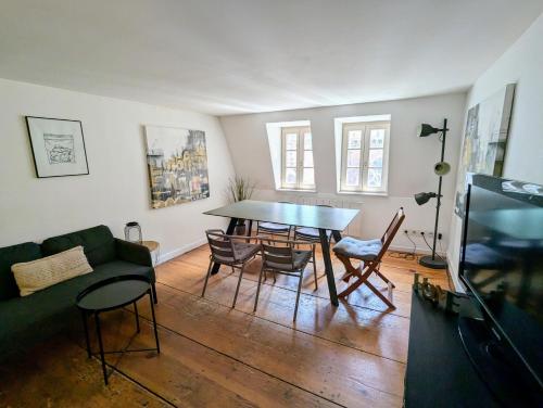 un salon avec une table, des chaises et un canapé dans l'établissement Triplex place de la cathédrale, à Strasbourg