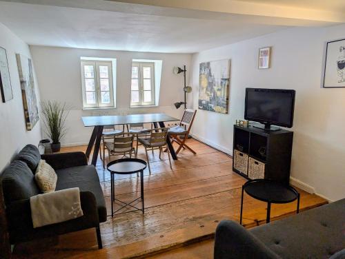un salon avec un canapé et une table avec des chaises dans l'établissement Triplex place de la cathédrale, à Strasbourg