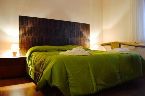 uma cama verde com duas toalhas em cima em La Casa Di Olga em Matera