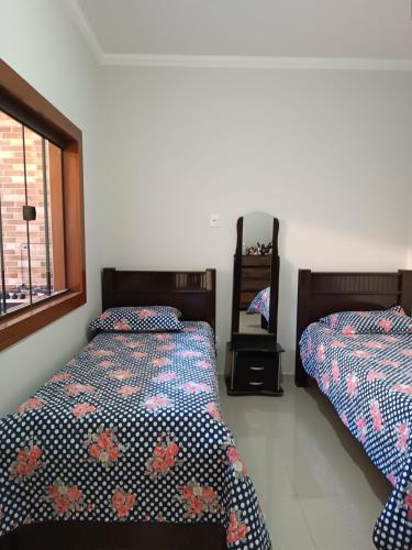 a bedroom with two beds and a window at Sua casa em nossa casa in Diamantina