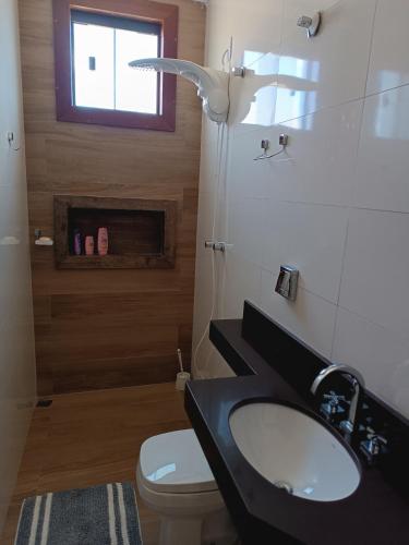 a bathroom with a sink and a toilet and a window at Sua casa em nossa casa in Diamantina