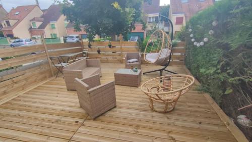 une terrasse en bois avec des chaises et une balançoire dans l'établissement Chambre à 30 min de Paris Montparnasse, à Villepreux