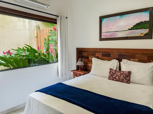 a bedroom with a bed and a window at Conchas do Mar Residence in Itacaré