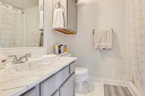 a white bathroom with a sink and a toilet at 3 Mi to Dtwn Fort Worth! Condo with Hot Tub and Pool in Fort Worth