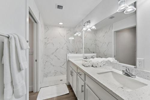 ein weißes Badezimmer mit Waschbecken und Spiegel in der Unterkunft Contemporary 3-bed,2-bath Home, Downtown Wpb! in West Palm Beach