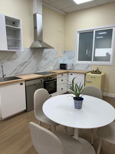 a kitchen with a white table and chairs at Playa América-Sal y Arena in Nigrán