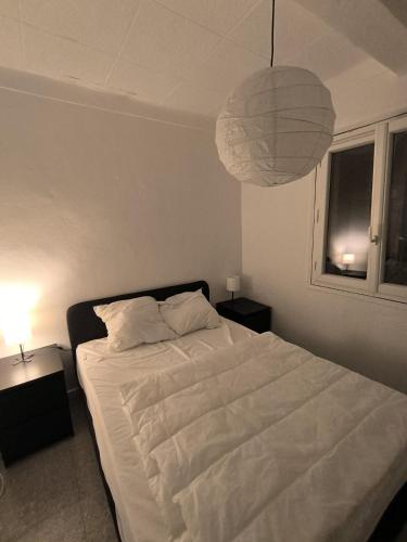 - une chambre avec un lit blanc et une lampe pendant dans l'établissement Villa Mané, à Antibes