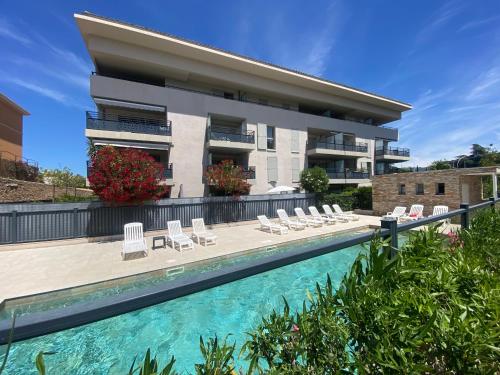 un immeuble avec une piscine devant un immeuble dans l'établissement Spacieux appartement avec jardin dans résidence de grand standing avec piscine, à Sanary-sur-Mer