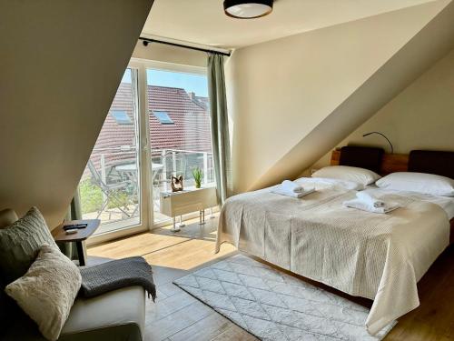 a bedroom with a bed and a large window at Ferienanlage Eldena Ferienwohnung 12 in Lobbe