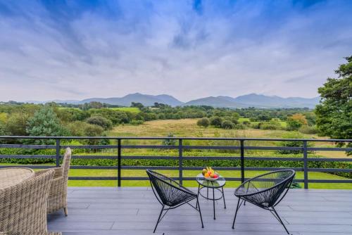 a patio with chairs and a table with a bowl of fruit at Greenane House in Killarney