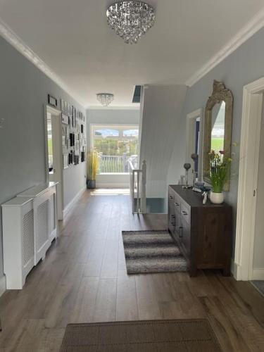 a hallway of a home with a dresser and a mirror at Greenane House in Killarney