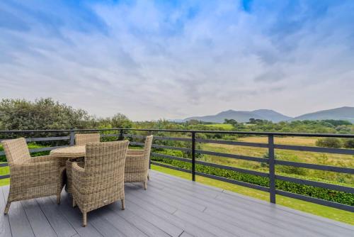 a table and chairs on a deck with a view at Greenane House in Killarney