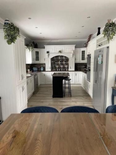 a kitchen with white cabinets and a wooden table at Greenane House in Killarney