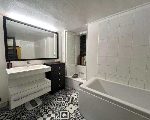 une salle de bain avec une baignoire blanche, un lavabo et un miroir dans l'établissement Maison Jack Disney à 12 minutes, à Chanteloup-en-Brie