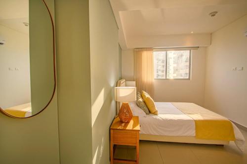 a small bedroom with a bed and a mirror at Exclusive Luxury Jr Suite 1BRD By ENCOR in Gaira