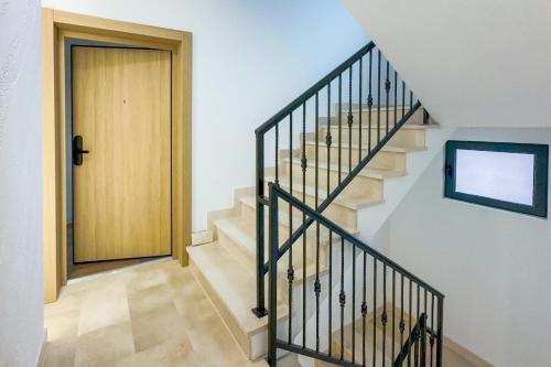 a hallway with a staircase leading to a door at North Apartments in Bijelo Polje