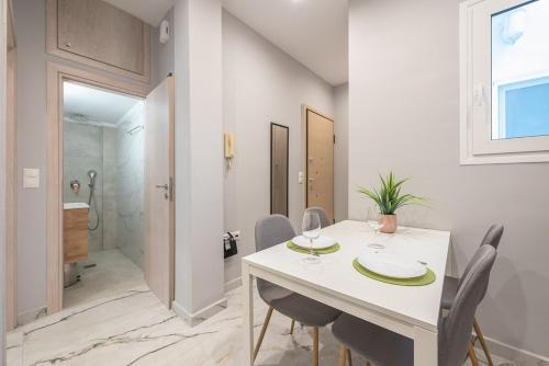 a white dining room with a white table and chairs at Athens Stay in Athens