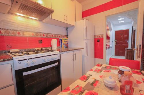 une cuisine avec une cuisinière et une table à l'intérieur dans l'établissement شقة في وسط المدينة هادئة ومناسبة للعائلات, à Charf