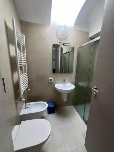 a bathroom with a toilet and a sink and a mirror at Il Borgo Apartments in Vieste
