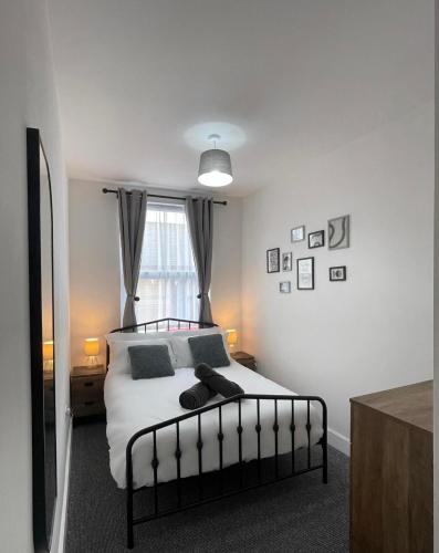 a bedroom with a bed with white sheets and a window at Montague Apartment-Spacious, Central & Free Parking in Worthing