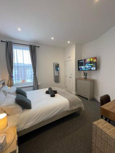 a bedroom with a large bed with a television on the wall at Montague Apartment-Spacious, Central & Free Parking in Worthing
