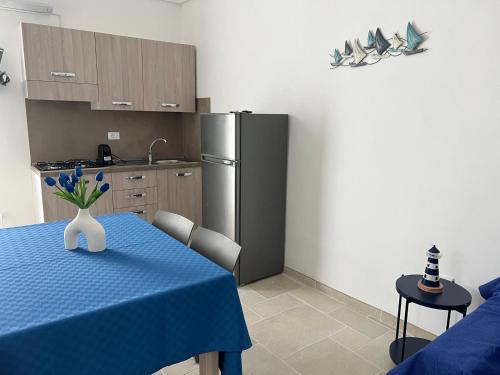 a kitchen with a table with a vase of flowers on it at Il Borgo Apartments in Vieste