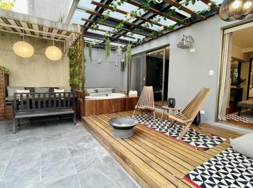 a bathroom with a tub and two chairs on a deck at Grand Cinema & Jacuzzi Appartment in Mexico City