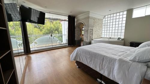 a bedroom with a bed and a tub and a television at Suite Chachani in Arequipa