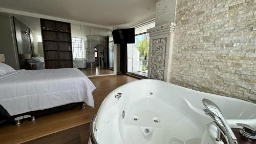 a white bath tub in a bedroom with a bed at Suite Chachani in Arequipa