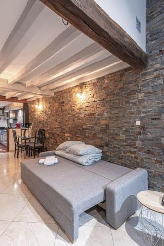 un lit dans une chambre avec un mur de briques dans l'établissement Strike & Chill - Duplex - Au Cœur de Dijon, à Dijon