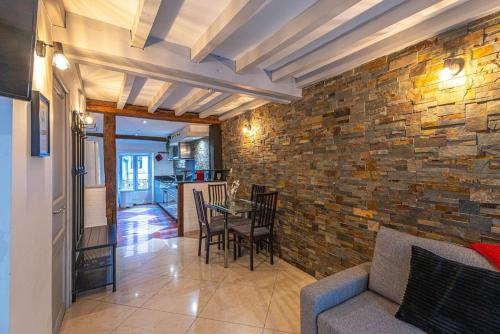 - un salon avec une table et un mur en briques dans l'établissement Strike & Chill - Duplex - Au Cœur de Dijon, à Dijon