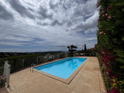 une piscine sur une terrasse avec un ciel nuageux dans l'établissement LES CIGALES, Superbe vue - Golfe de Sainte-Maxime, à Sainte-Maxime