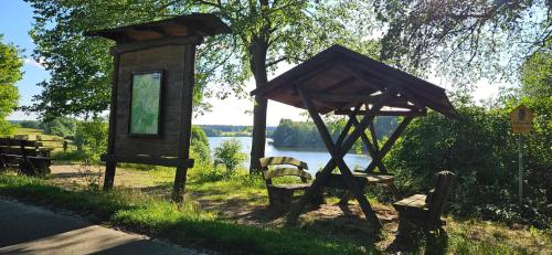 a small wooden structure with chairs and a tree at Mietwohnwagen in Carpin