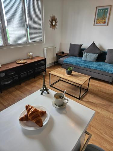 - un salon avec une table et une assiette de pain dans l'établissement Studio cozy proche Versailles, à Toussus-le-Noble