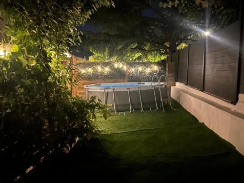 - une arrière-cour de nuit avec un bain à remous et des lumières dans l'établissement Maison moderne jardin piscine et parking prives, près d'Aix Centre, à Venelles