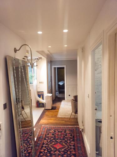 un couloir avec un miroir et une salle de bains dans l'établissement Pic de Nôtre Dame, Charming Suites Paris, à Paris