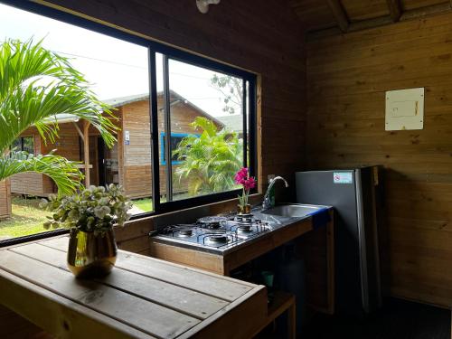 a kitchen with a stove and a sink and a window at Cabañas La Moraleja Paraíso Costero in Necoclí